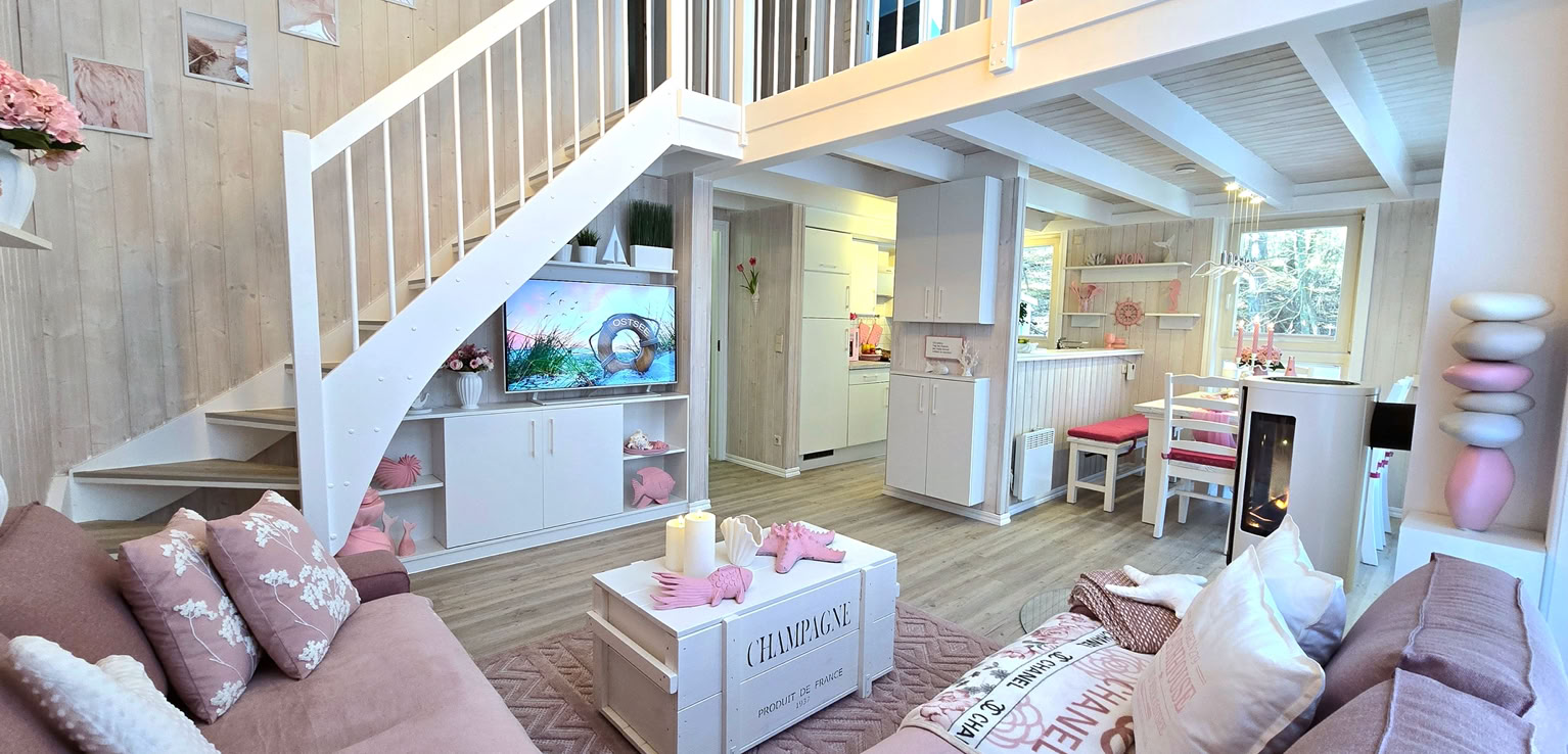 Wohnzimmer mit pink Sofas, einem Couchtisch, einem Fernseher, einer Treppe und einem offenen Obergeschoss.